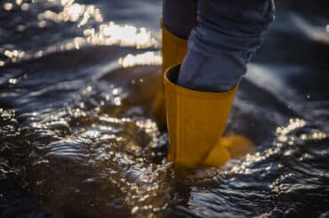 suspeita-de-leptospirose-pessoa-com-botas-amarelas-de-chuva-caminhando-na-enchente